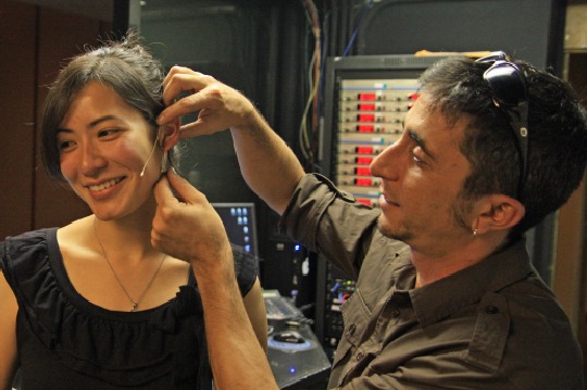 Alan Ceccarelli placing an E6 Omni Earset microphone on a student.